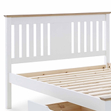 A white wooden bed frame with slatted base, partially assembled, isolated on a white background.