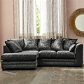 A plush, dark gray sectional sofa with multiple cushions; situated in a room with beige curtains, a window with a garden view, and a decorative golden mirror on the wall.