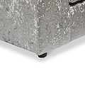 Grey upholstered bed frame with a textured fabric and a leg visible against a white background.