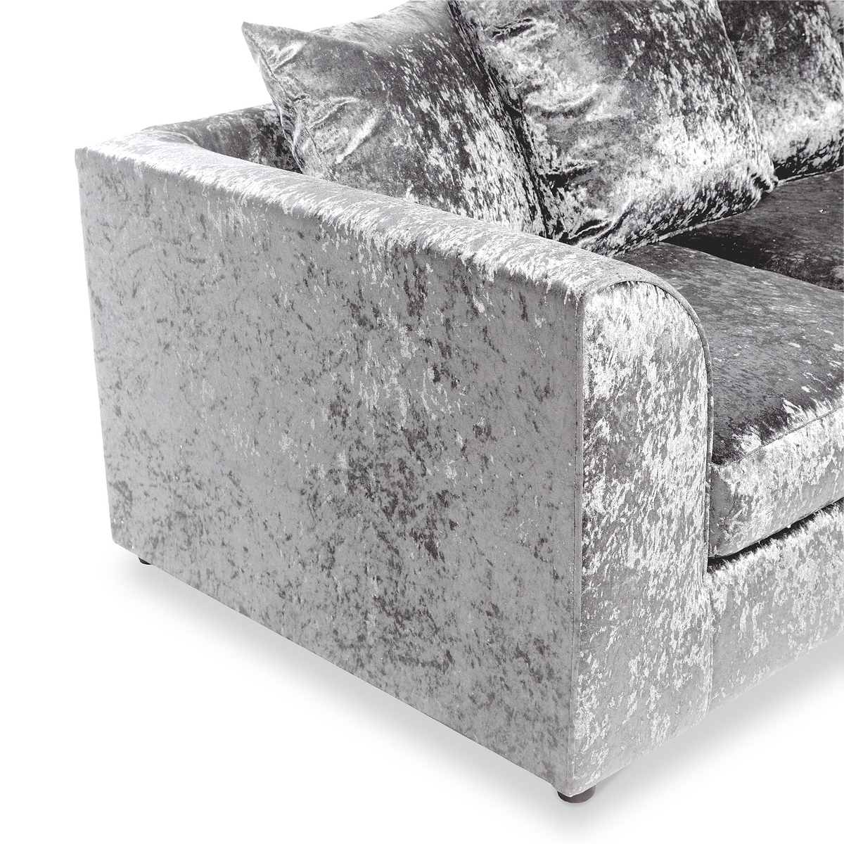 A velvet-textured sofa with plush cushions, in a neutral color, rests against an isolated white background.