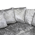 Four silver velvet cushions rest against each other on a matching couch, isolated against a white background.