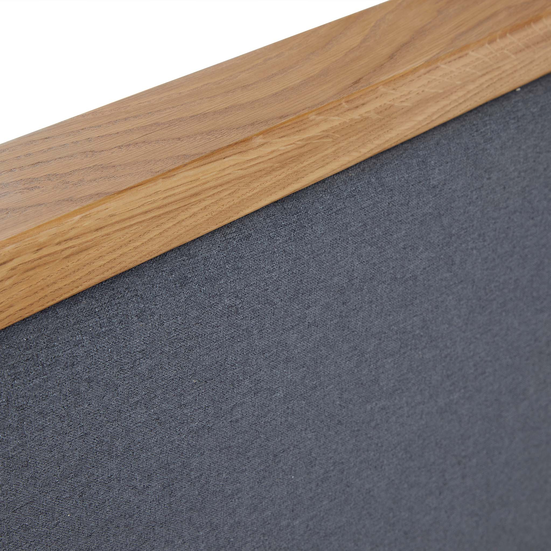 A wooden frame corner overlays a textured gray surface, possibly part of a bulletin board or artwork, with a focus on material details and junction craftsmanship.