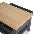 A rectangular wooden tabletop sits slanted on a black metal frame, suggesting an adjustable or convertible piece of furniture, depicted against a plain white background.
