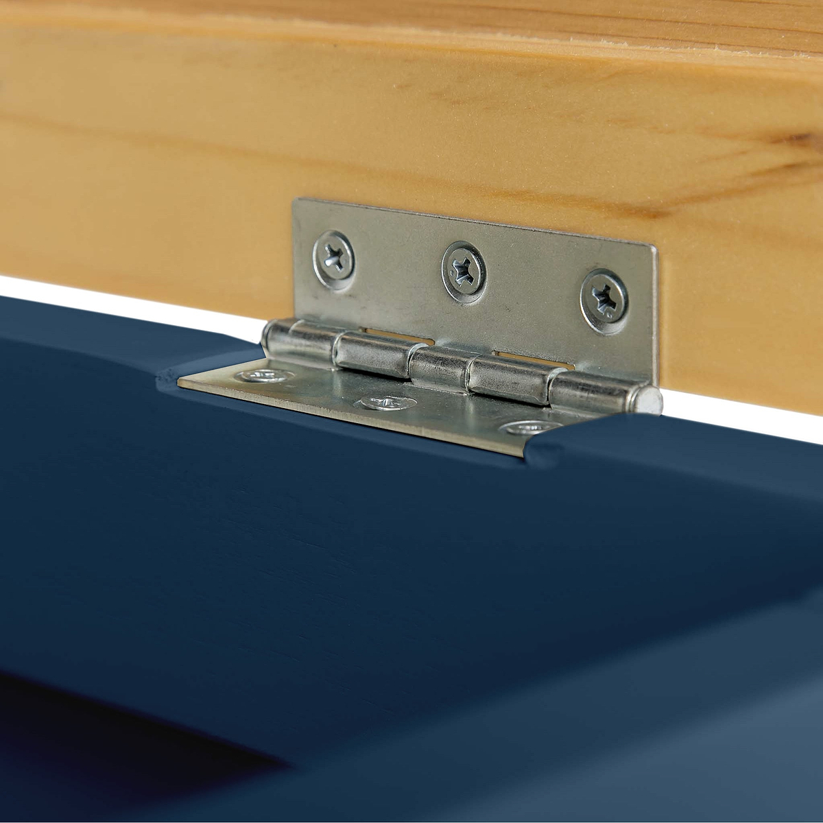 A metal hinge connects a wooden piece to a blue surface, allowing pivoting motion. This is a close-up of the hardware component in a simple indoor setting.