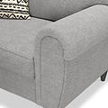 A grey fabric sofa arm, with a patterned cushion resting against its backrest.