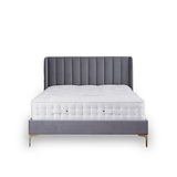 A grey upholstered bed with a tufted headboard is stationary against a white background. A plush white mattress sits atop the frame.