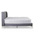 A single bed with mattress, featuring a grey upholstered headboard, rests stationary against a plain white background.