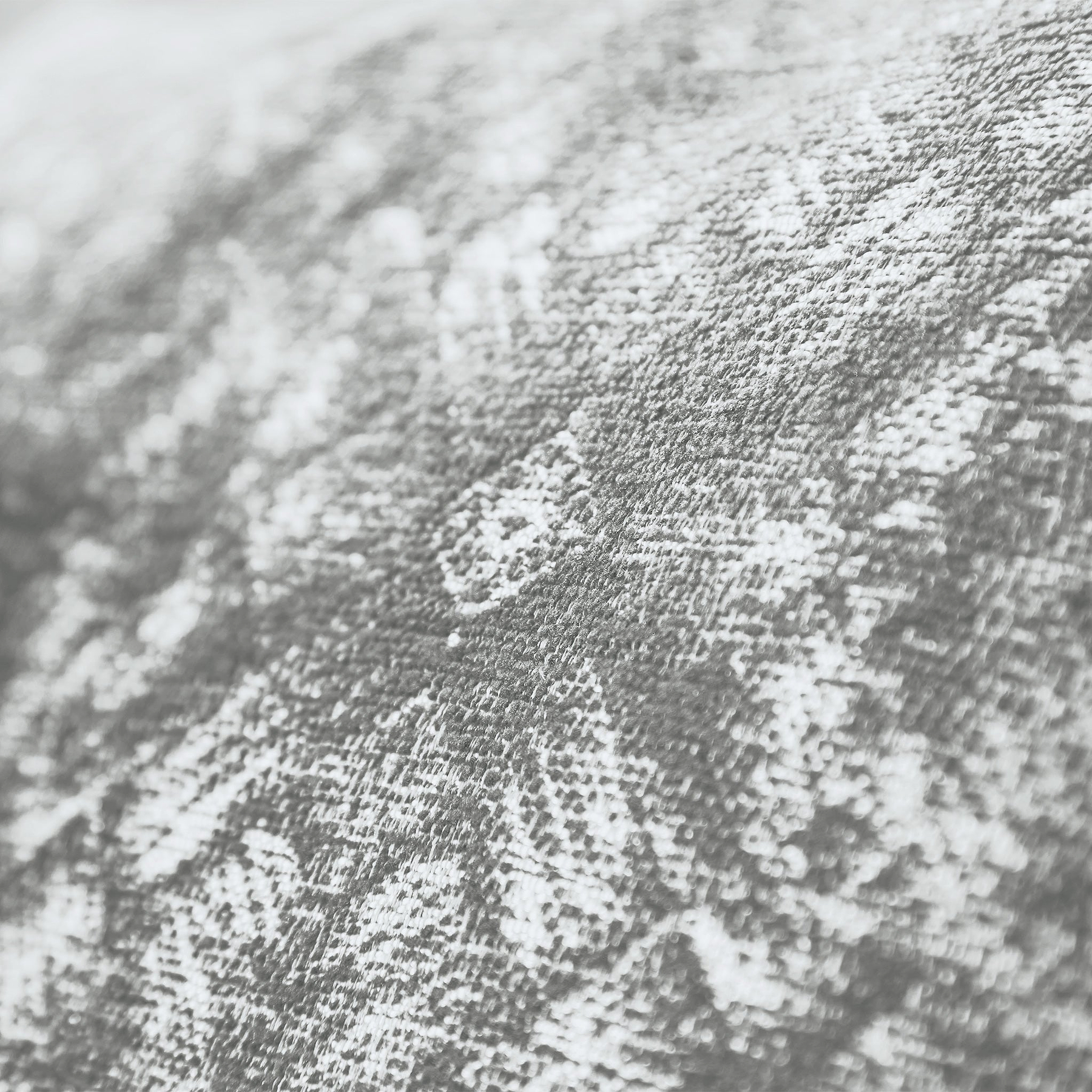 A textured fabric with a mottled pattern, close-up shot creating an abstract, tactile surface. The context is indeterminate due to the close focus. No text present.