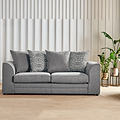 A grey sofa with cushions sits idle in a room with a vertical slat wall, a potted plant, and soft lighting.