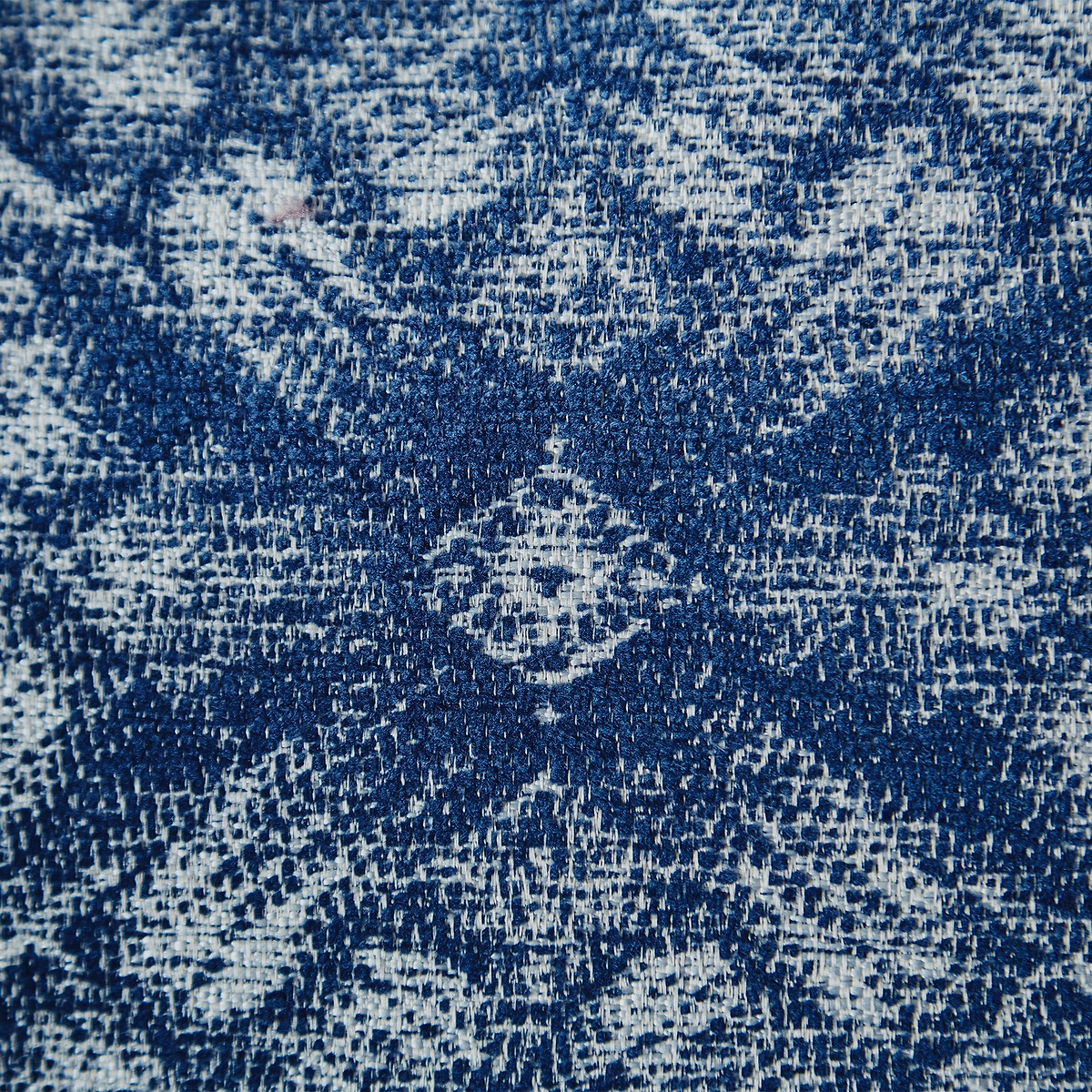 A close-up texture of blue denim fabric with white distressed patterns, no distinct action, just presenting the material and wear.