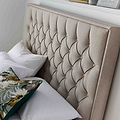 close up of button tufted headboard on the Sutton Oatmeal Upholstered Fabric Ottoman Storage Bed