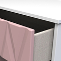 A pink geometric sculpture stands between a white desk and a beige upholstered chair, creating an abstract, modern aesthetic.