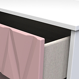 A pink geometric sculpture stands between a white desk and a beige upholstered chair, creating an abstract, modern aesthetic.