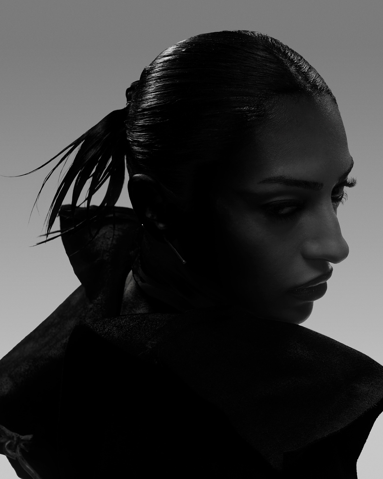 Model in profile within the hazy atmosphere of ioannes A Salon.