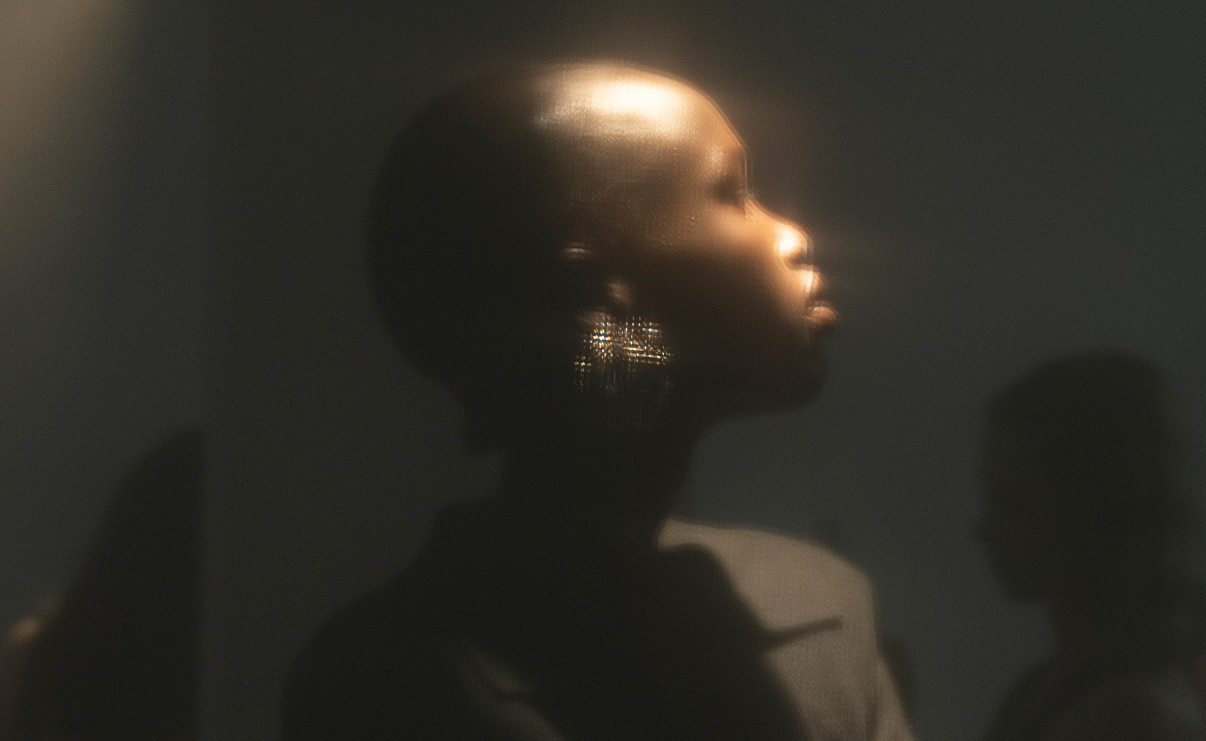 Model in profile within the hazy atmosphere of ioannes A Salon.