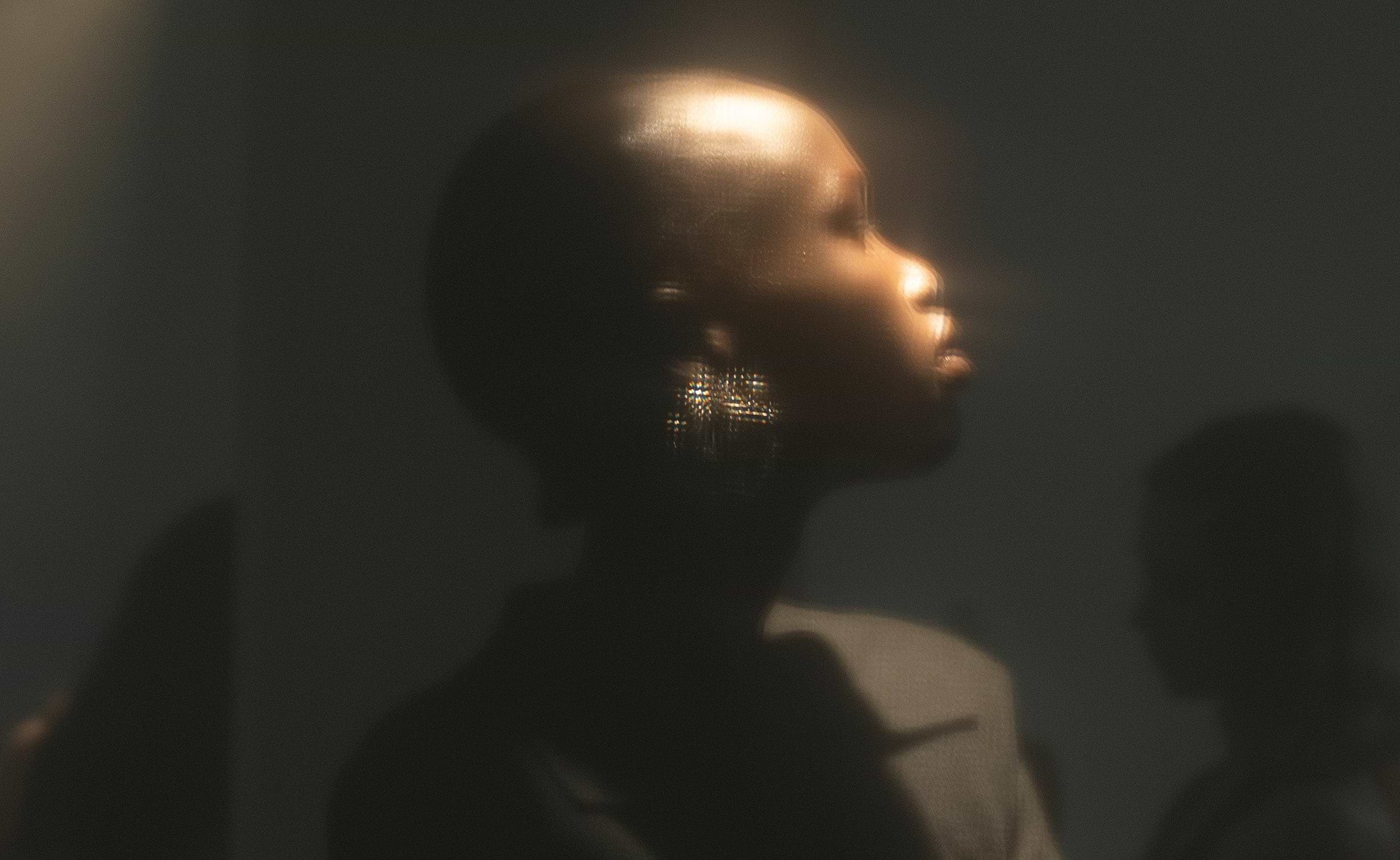Model in profile within the hazy atmosphere of ioannes A Salon.