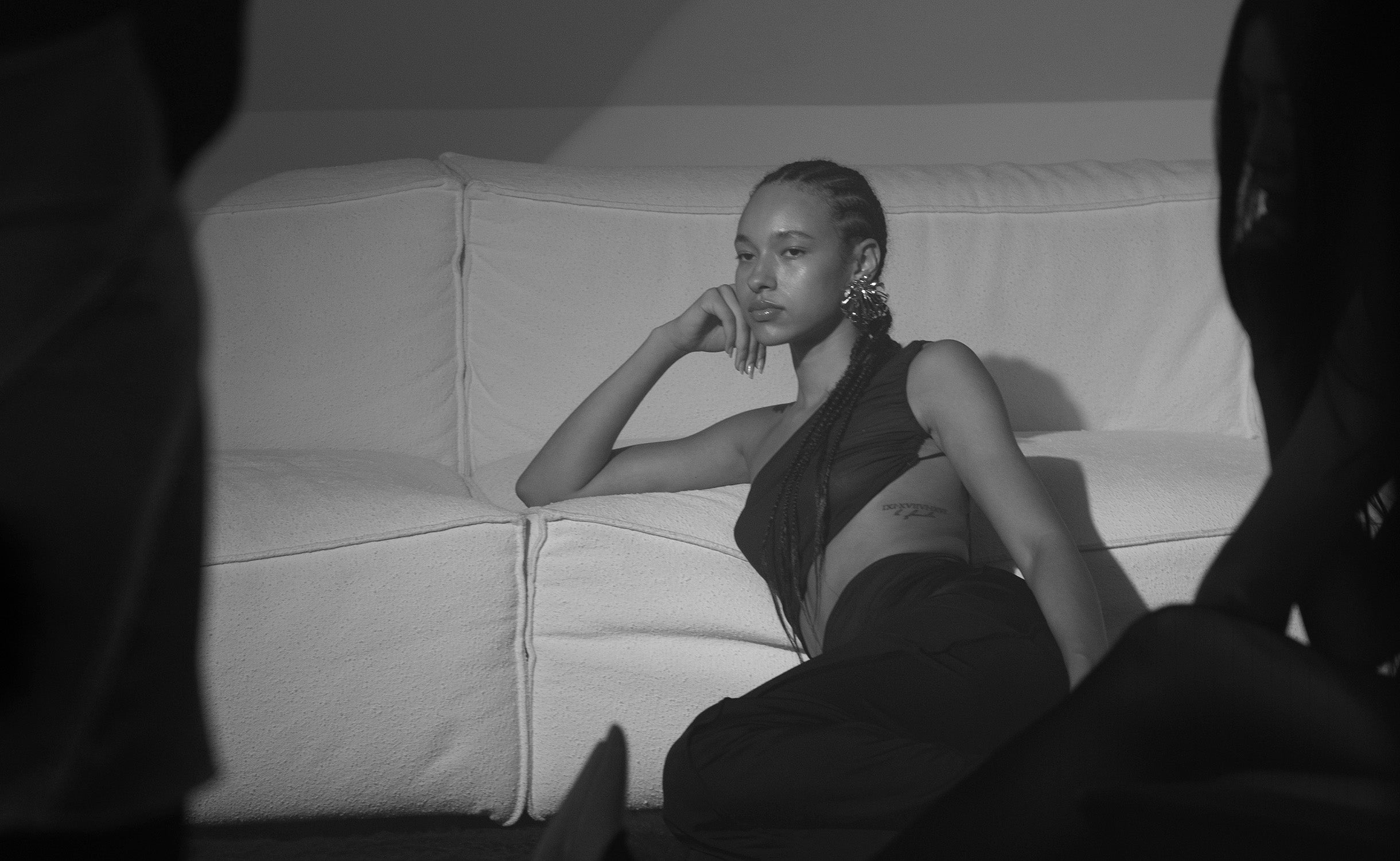 Model reclining on a sofa during the ioannes A Salon presentation in Berlin.