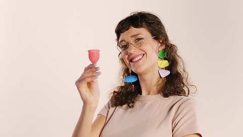 Model holding a Saalt Cup and smiling.