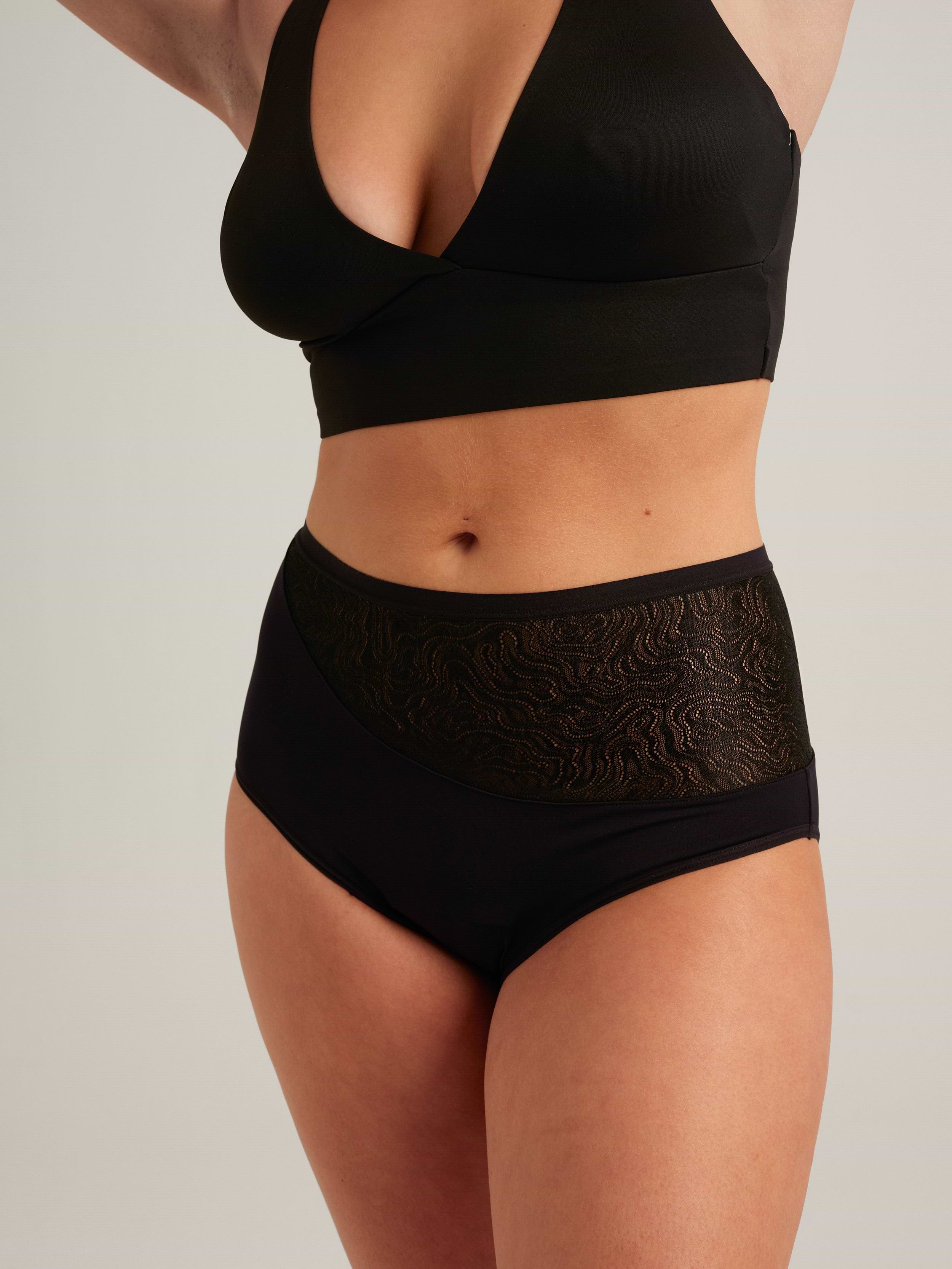 Model wearing black bralette and high-waisted period underwear with lace mesh panel detail.