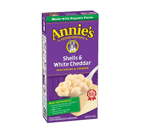 Box of Annie’s Shells & White Cheddar macaroni and cheese on a light gray background.
