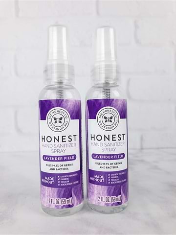 Two bottles of Honest lavender field hand sanitizer spray on a white surface.