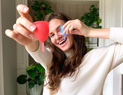 woman holding menstrual cups
