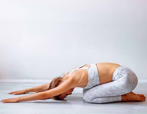 Person in child's yoga pose