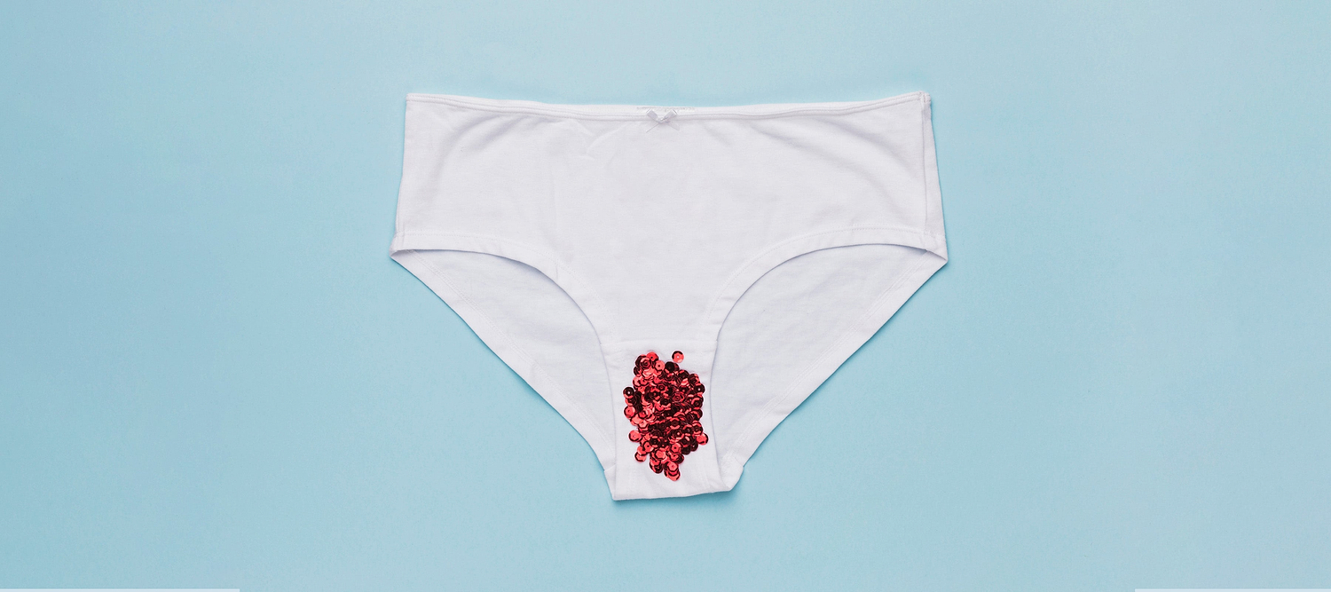 White underwear with red beads placed on the front, against a blue background.