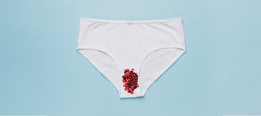 White underwear with red beads placed on the front, against a blue background.