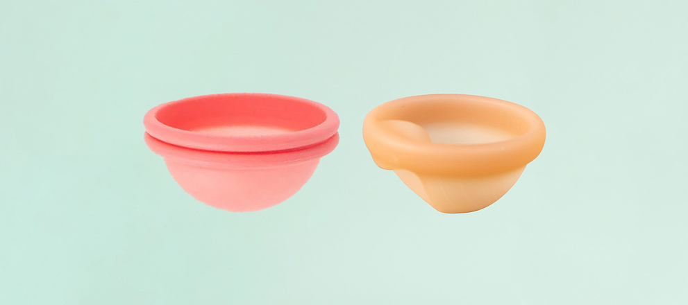 Pink and beige menstrual discs displayed side by side on a light blue background.