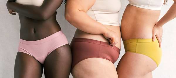 Diverse models wearing pink, burgundy, and yellow seamless underwear together.