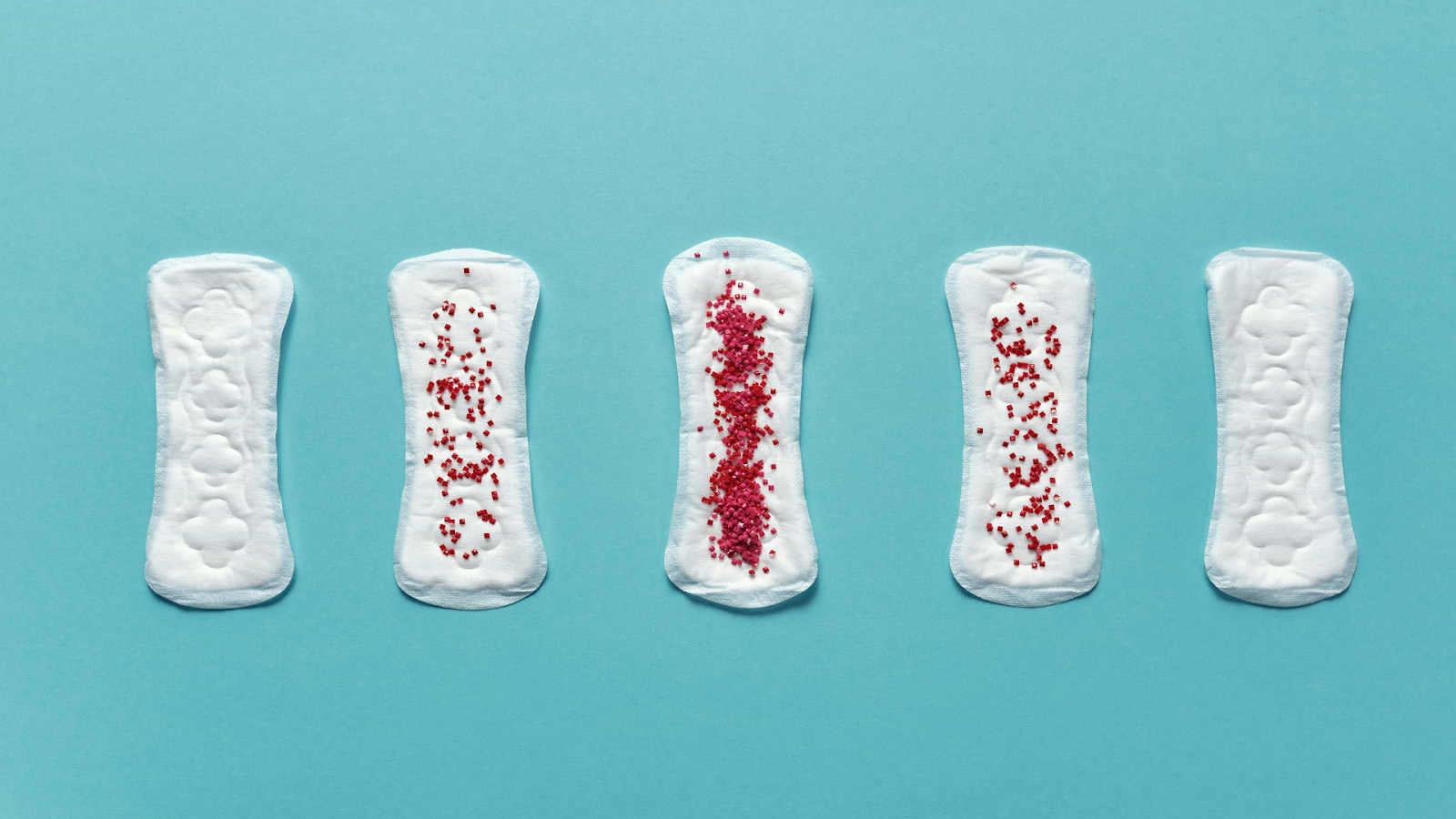 Five sanitary pads on a blue background, illustrating varying menstrual flow levels with red beads.