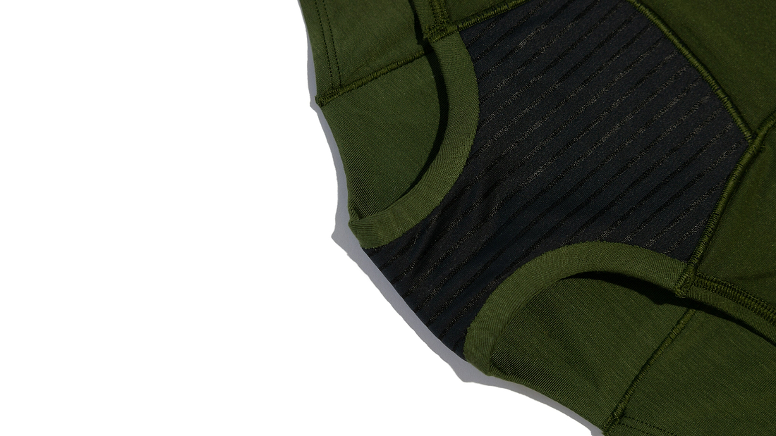 Close-up of green and black period underwear with textured fabric details.