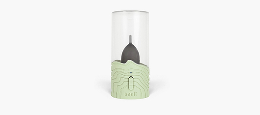 Portable Saalt menstrual cup steamer with a black menstrual cup inside a transparent container.