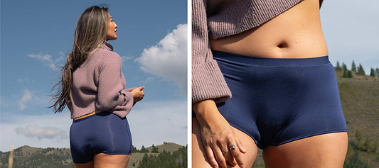 Woman outdoors wearing navy leakproof underwear and sweater, with close-up detail against a mountain landscape.