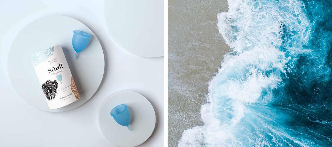 Flat lay of blue menstrual cups with packaging beside an aerial ocean wave scene.