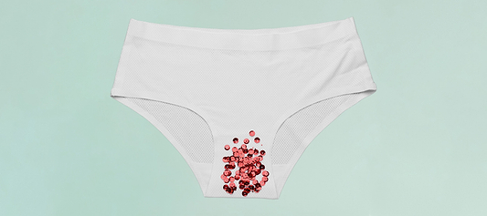 White underwear with red sequins symbolizing menstrual flow on a light green background.