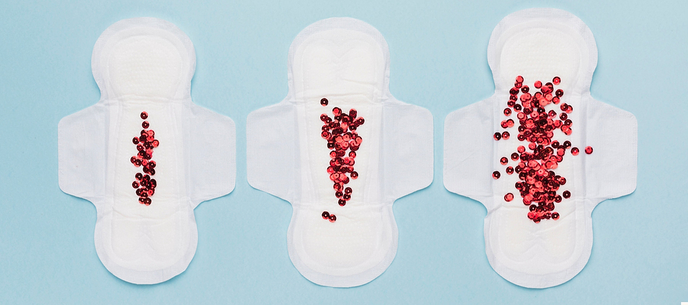 Three sanitary pads with increasing amounts of red beads, illustrating light to heavy flow.