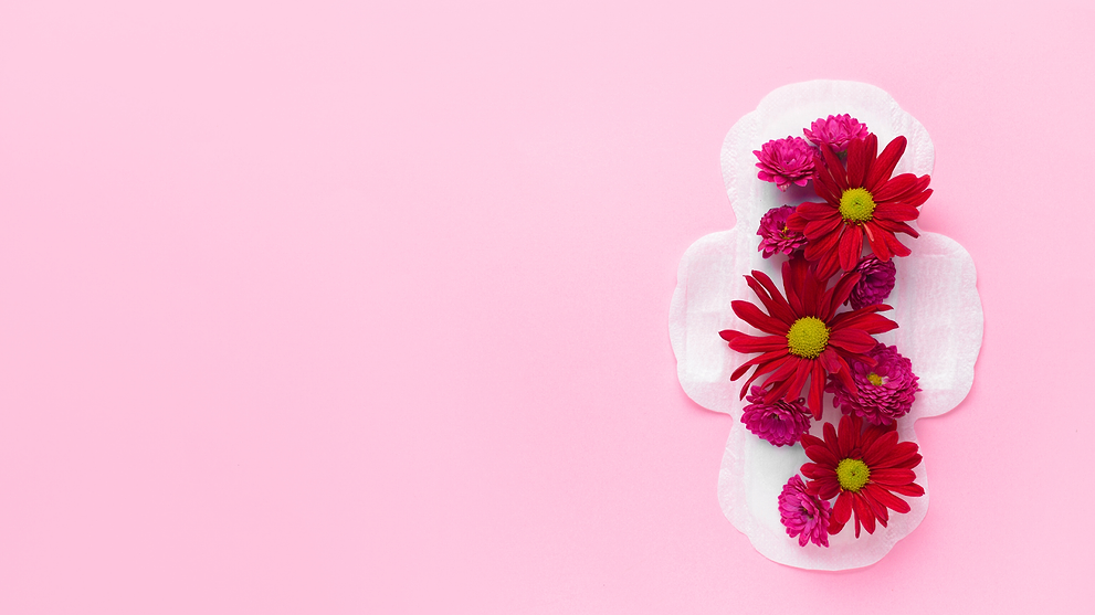 Sanitary pad decorated with red and pink flowers on a pastel pink background.