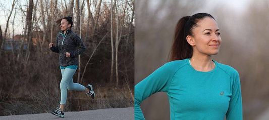 Woman jogging outdoors and posing in teal athletic wear on a wooded trail.