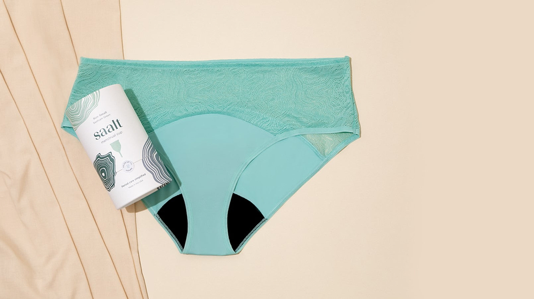 Reusable period underwear and menstrual cup packaging displayed on a neutral background