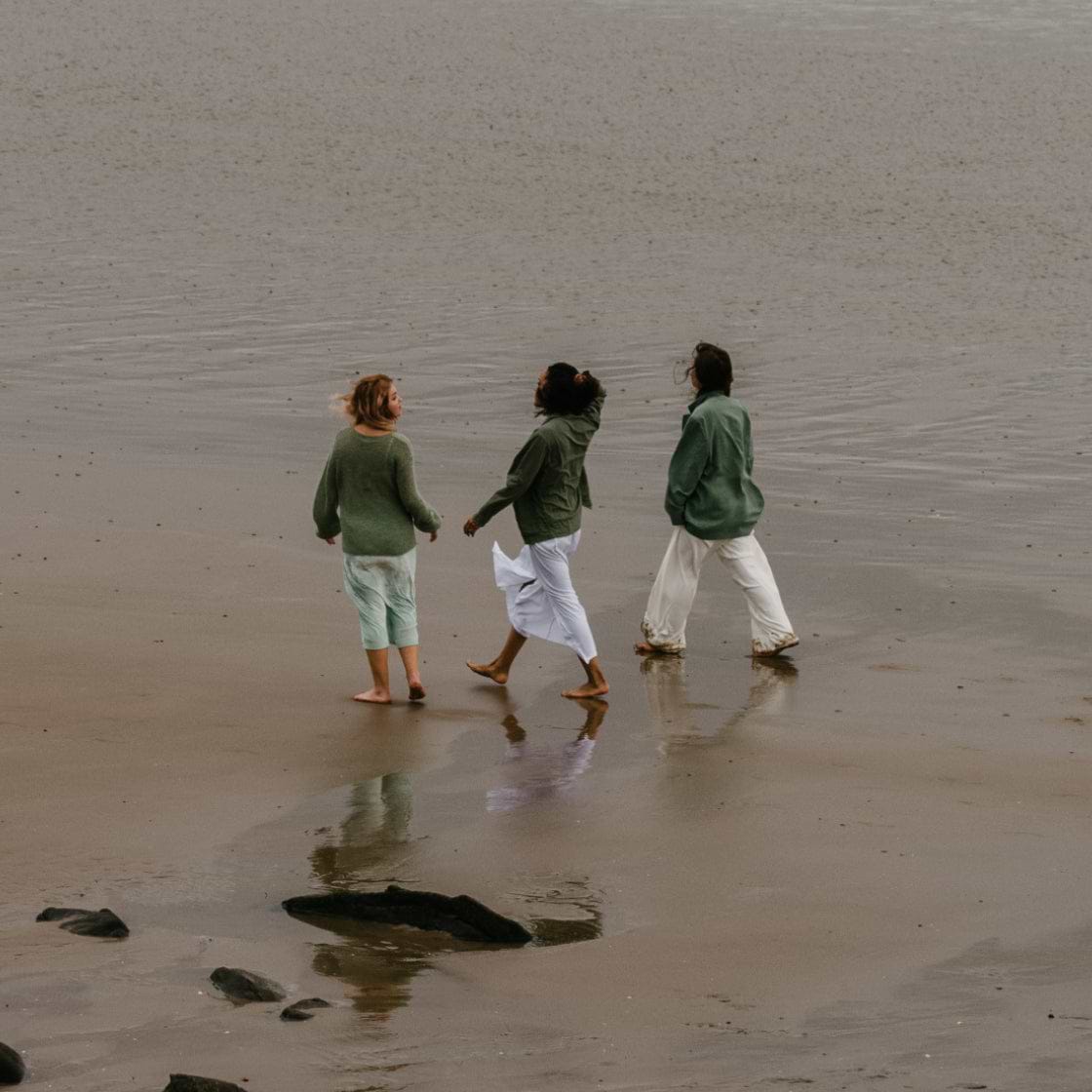 Three UK women walking in the sand on the beach 