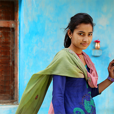 Kenya female wearing blue dress in-front of a blue wall