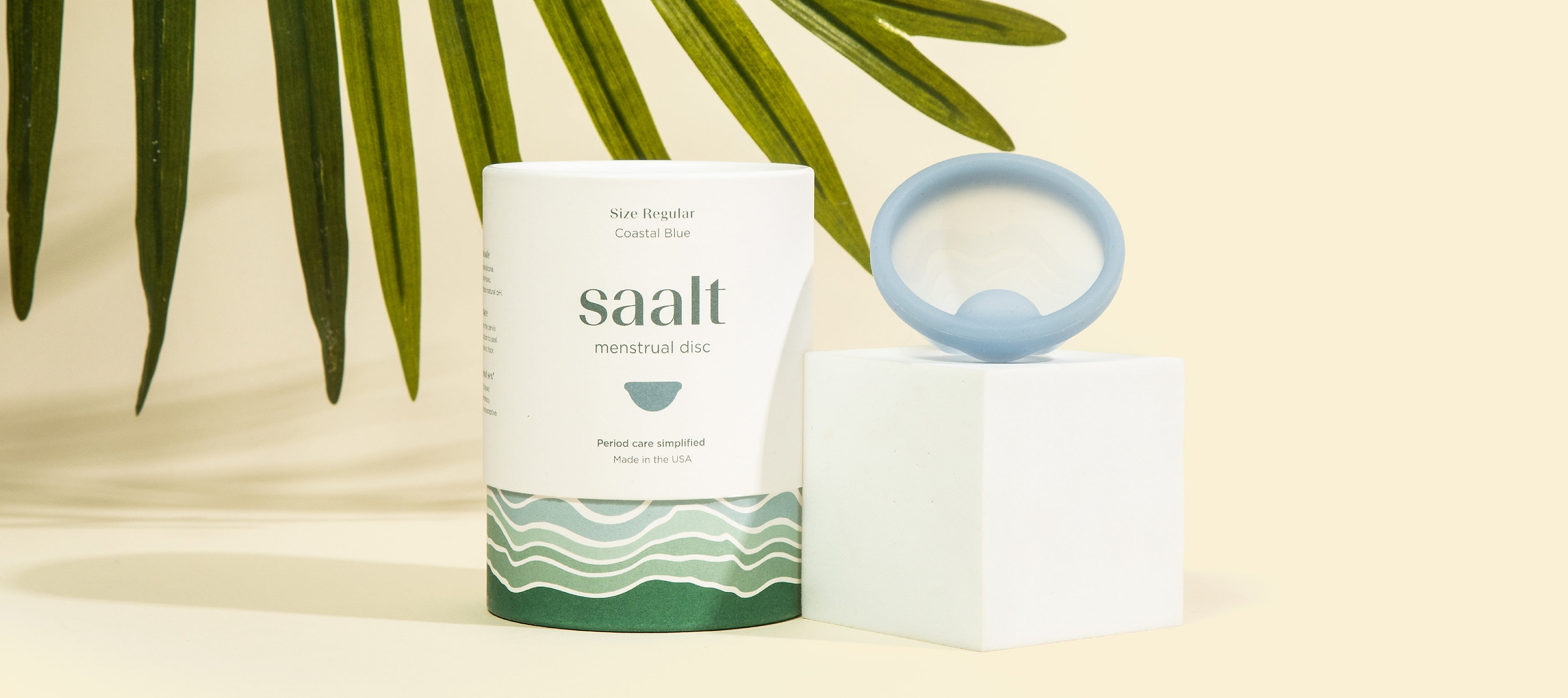 Coastal blue menstrual disc sitting next to branded packaging 