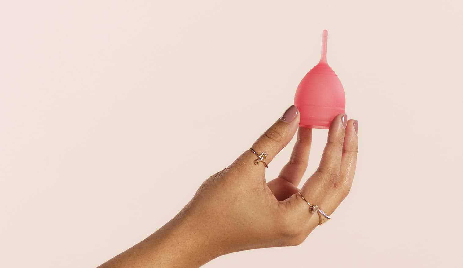Female hand holding pink/reddish saalt cup upright
