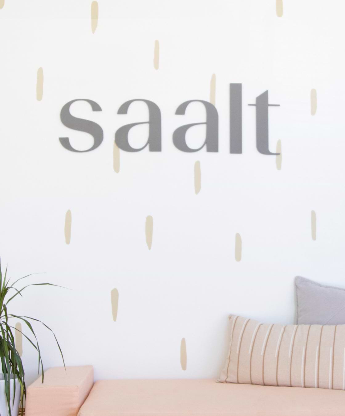 Saalt company name on white and gold wall