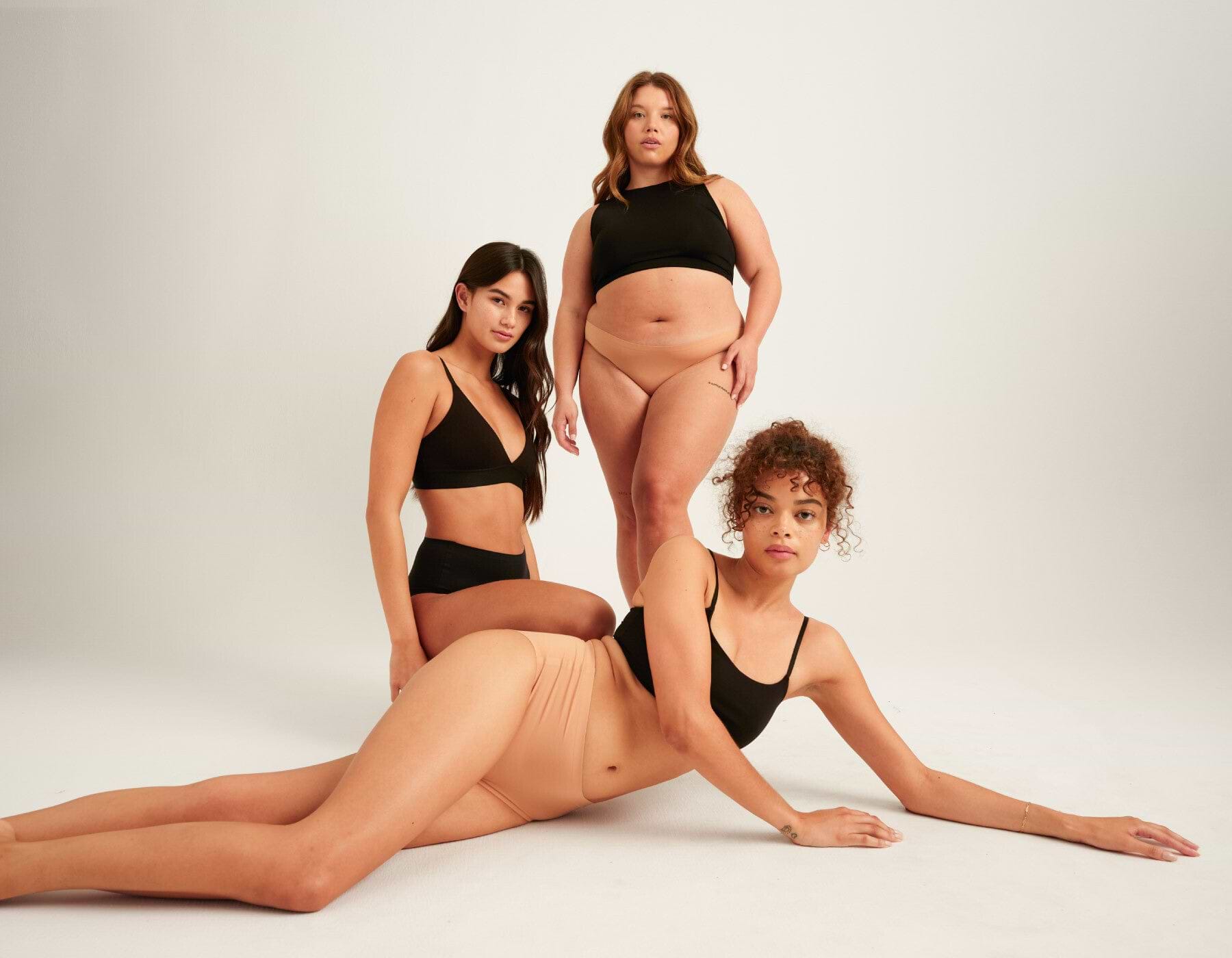 Three females wearing black tops with brown leak-proof underwear