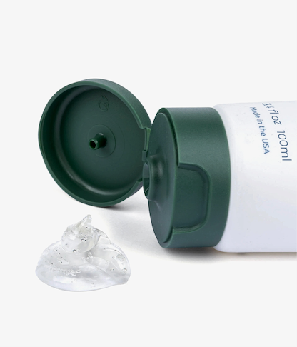 Green and white tube with a clear suction cup on a white background