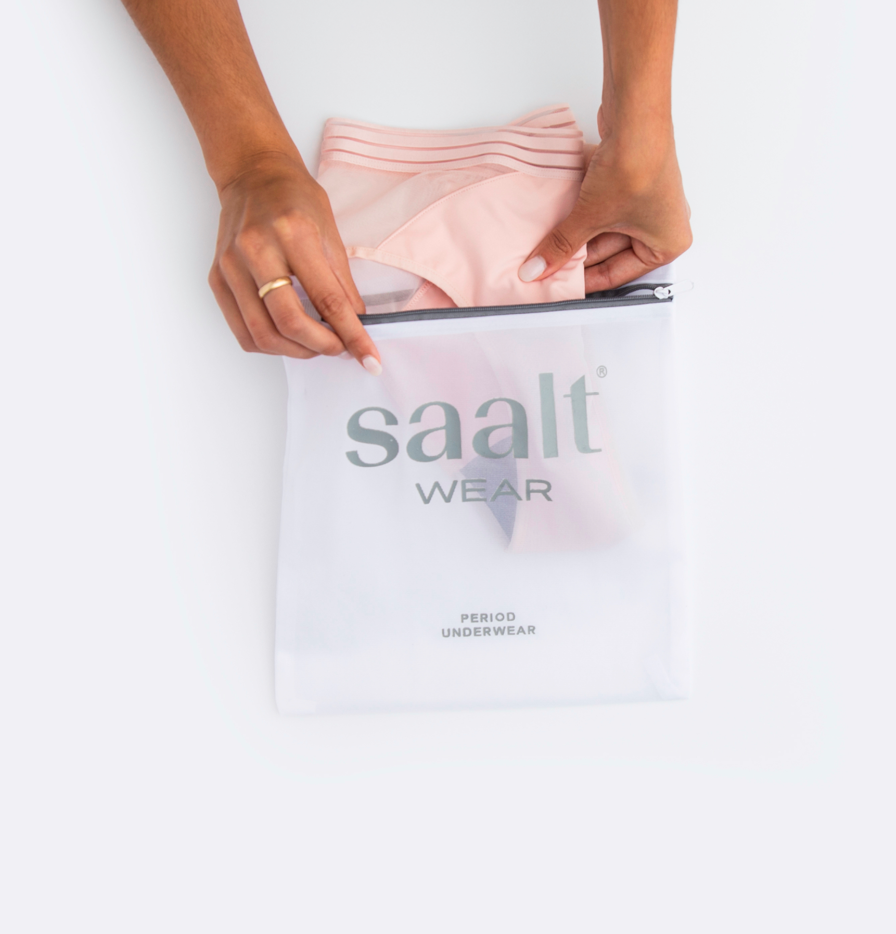 Female placing period underwear in Saalt packaging