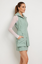 The Best Travel Vest. Woman Showing the Side Profile of an Embossed Delaney Vest in Cheetah Sage.